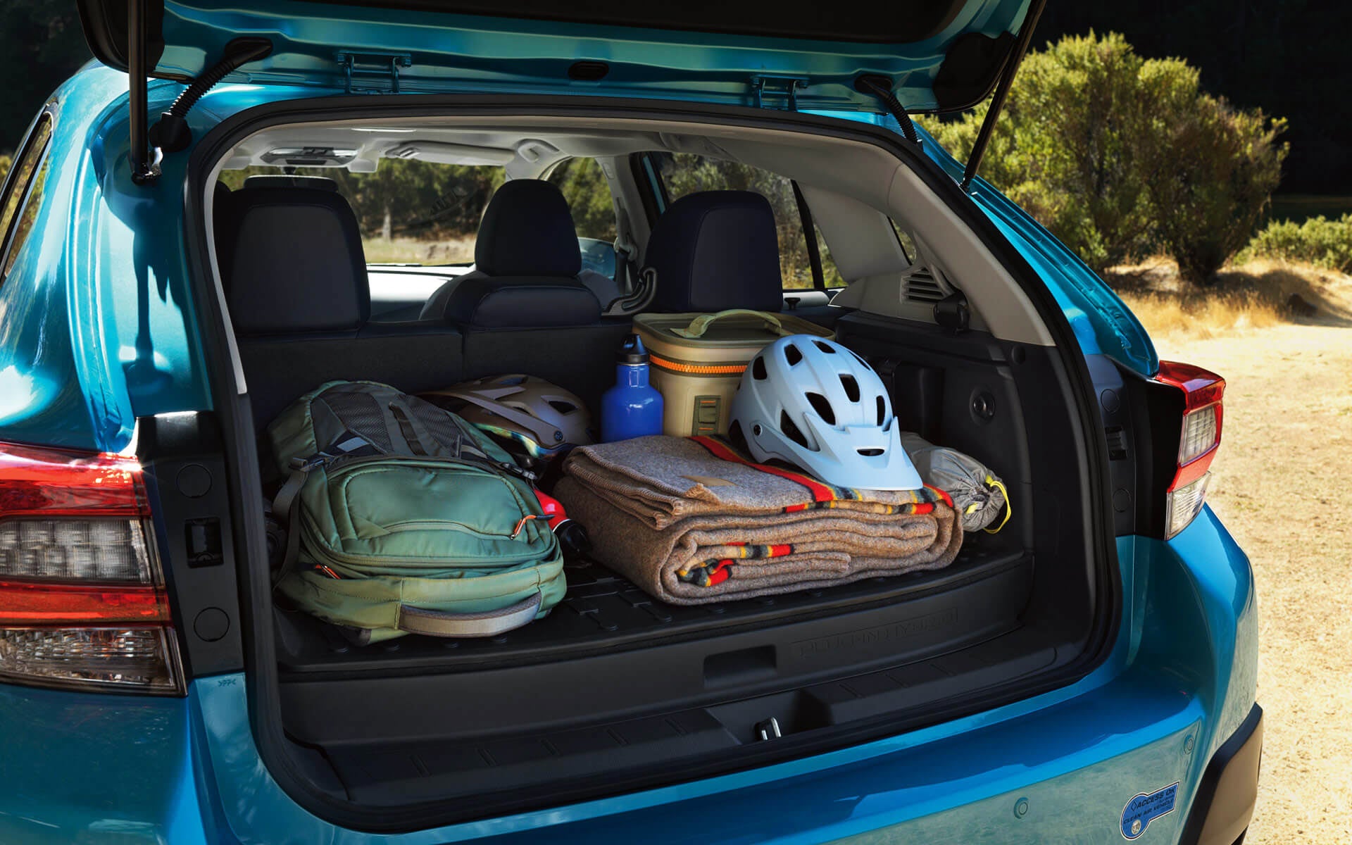 A backpack, blanket, and bike helmet in the rear cargo area of a Crosstrek Hybrid | Royal Moore Subaru in Hillsboro OR