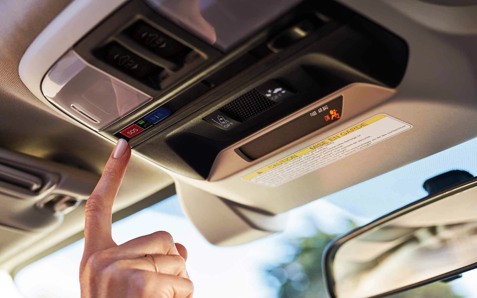 A finger pressing the Crosstrek Hybrid's SOS emergency assistance button | Royal Moore Subaru in Hillsboro OR