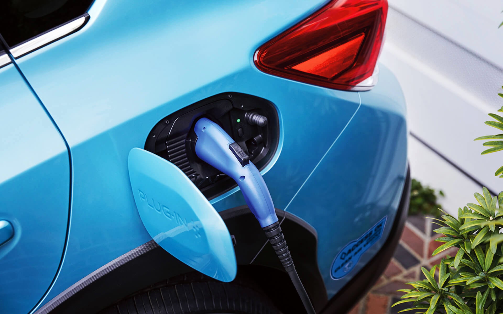A close-up of the Subaru Crosstrek Hybrid's charging port with charging cable plugged in | Royal Moore Subaru in Hillsboro OR