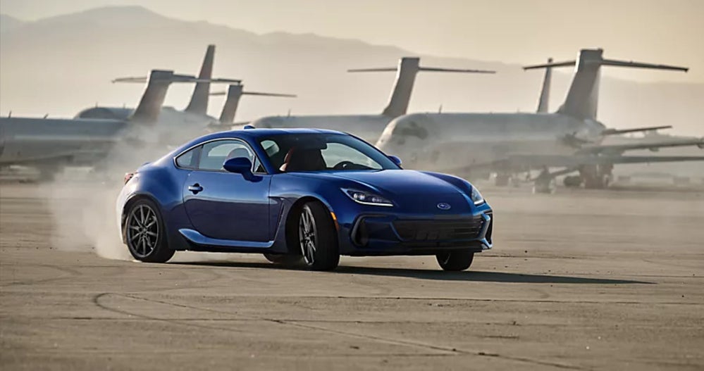 A blue Subaru BRZ driving around an airfield.